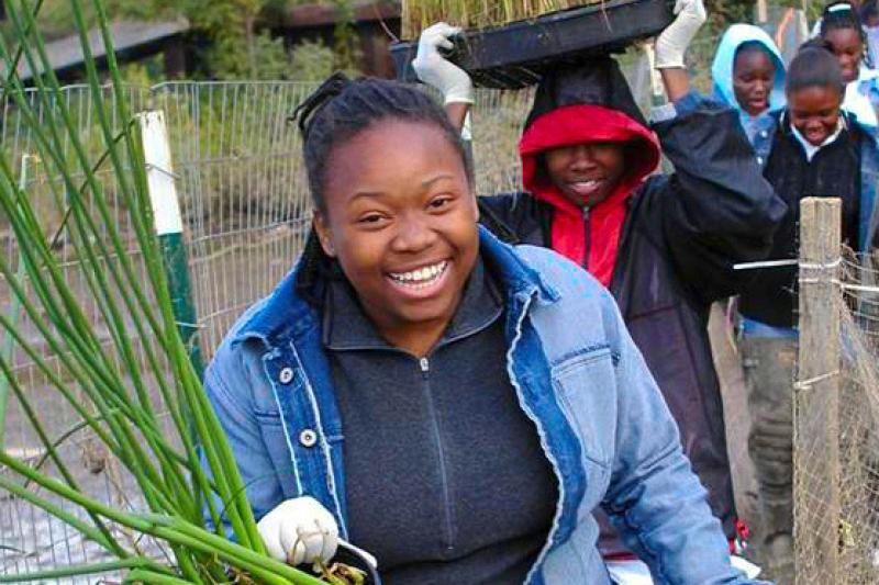 Girl planting vegetation at a habitat restoration project.